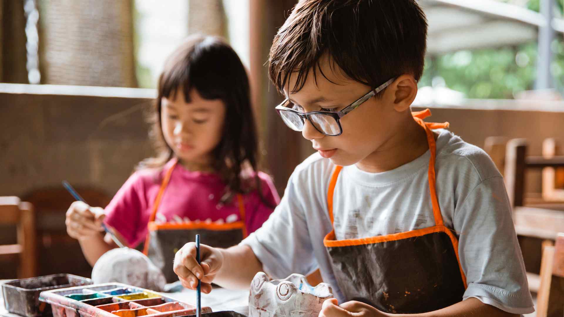 Child arranging a breakfast tray with a handmade card for Mother's Day breakfast in bed