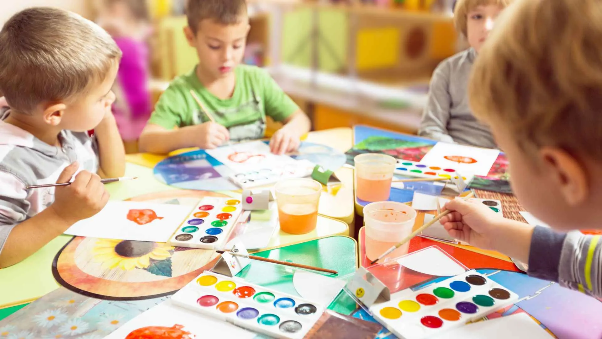 Toddler pressing a painted handprint onto paper to make a Mother's Day flower card