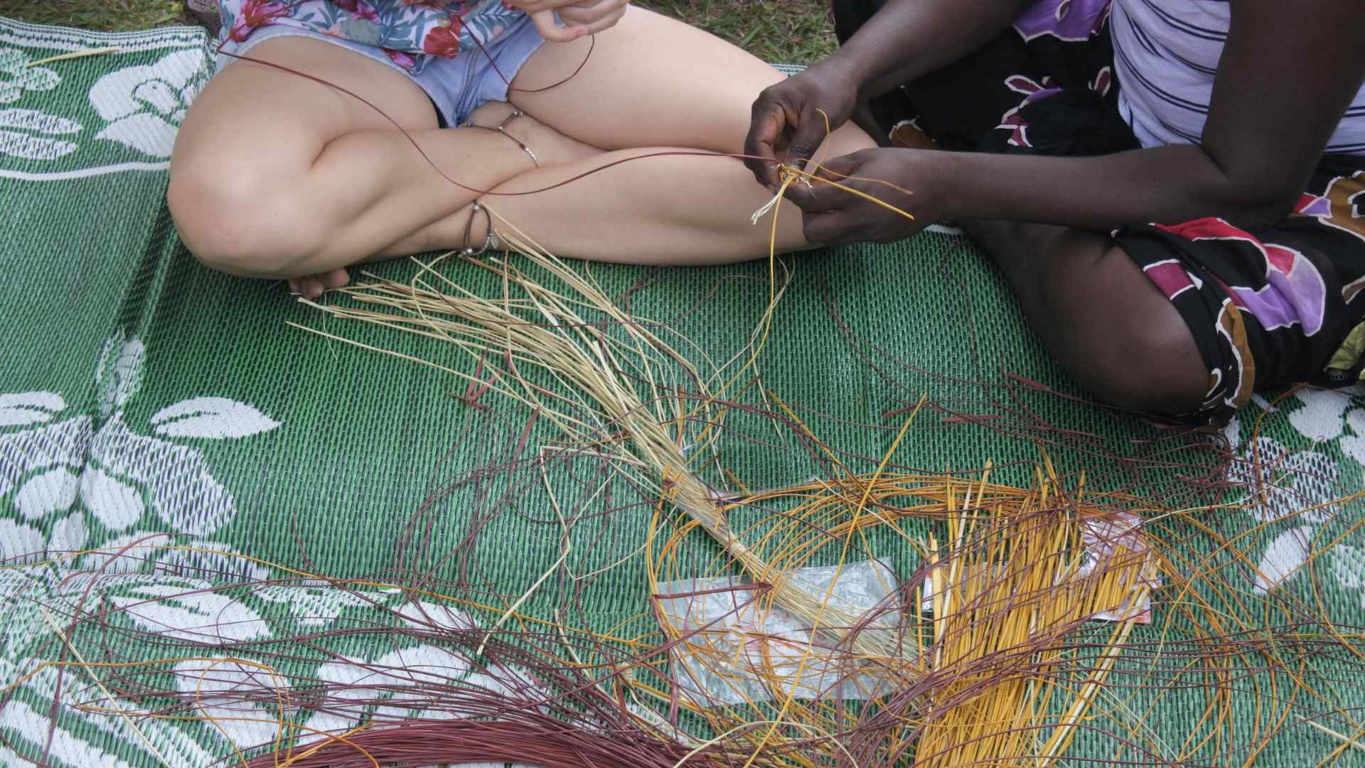 Kid-friendly dreamcatcher supplies including a hoop, yarn, beads, and feathers laid out on a table